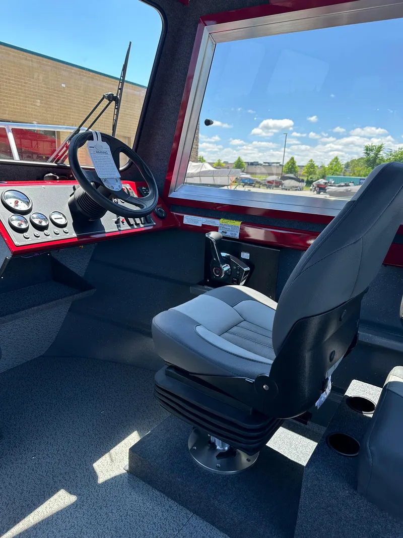Slide: The Image of 2024 Spartan 220 Maximus boat cockpit with steering wheel and captain's chair. - 38