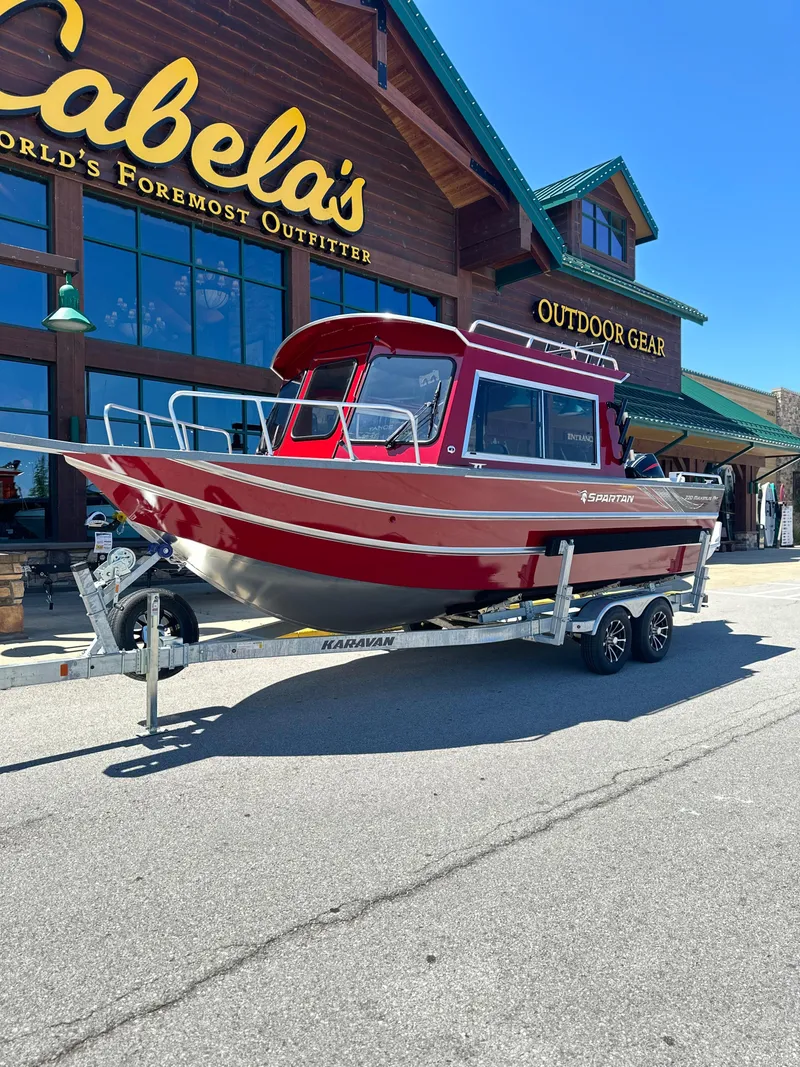 Slide: The Image of 2024 Spartan 220 Maximus boat on trailer outside Cabela's outdoor gear store. - 4