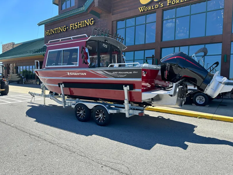 Slide: The Image of 2024 Spartan 220 Maximus boat on trailer outside hunting and fishing store. - 5