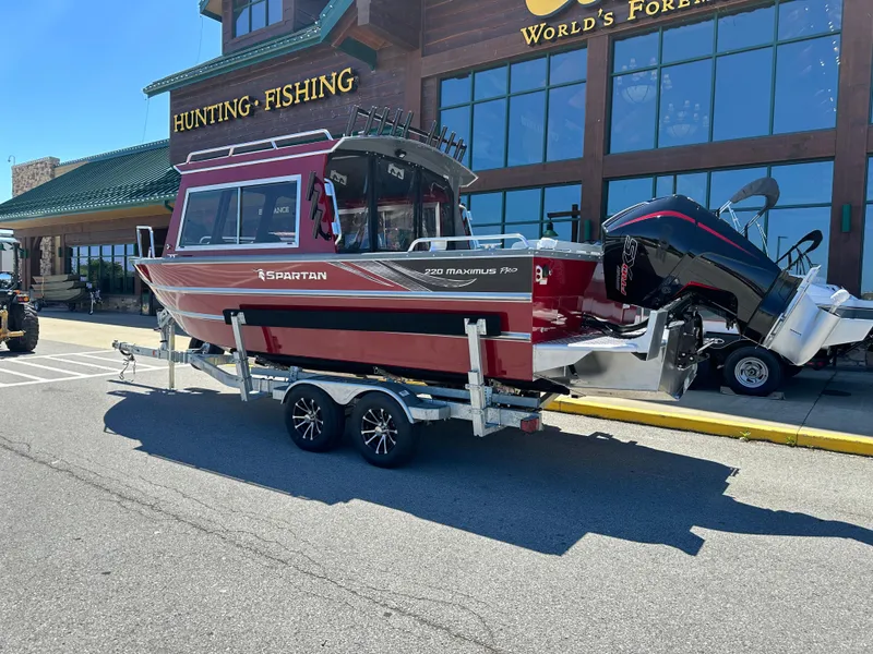 Slide: The Image of 2024 Spartan 220 Maximus boat on trailer outside hunting and fishing store. - 6