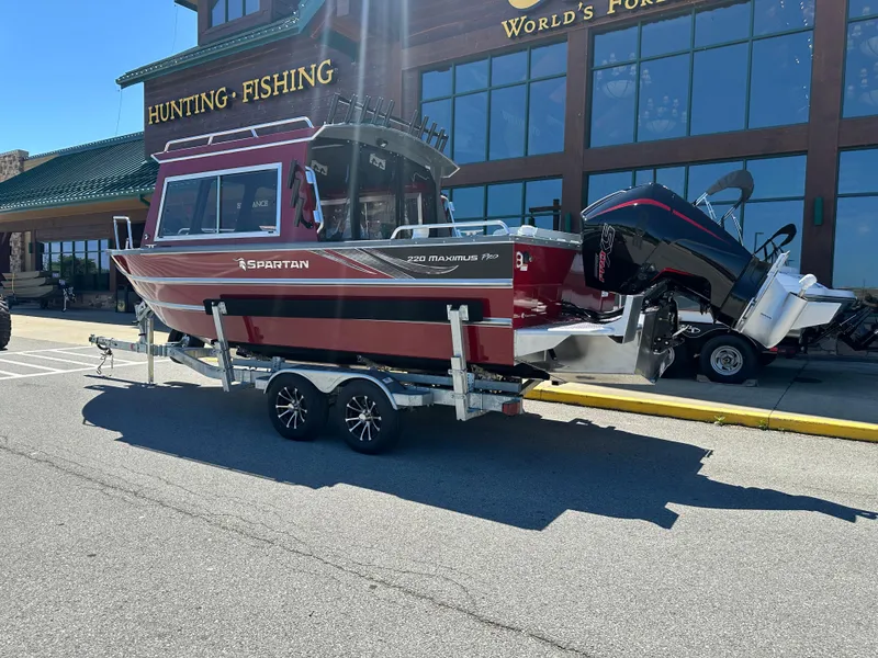 Slide: The Image of 2024 Spartan 220 Maximus boat on a trailer outside a hunting and fishing store. - 7