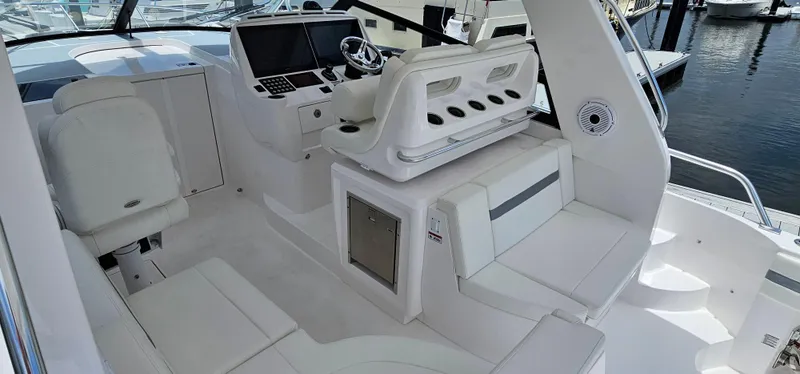 Slide: The Image of 2022 Intrepid 438 Evolution boat interior with white seating and modern helm. - 10