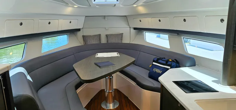 Slide: The Image of 2022 Intrepid 438 Evolution yacht interior with U-shaped seating and table. - 15