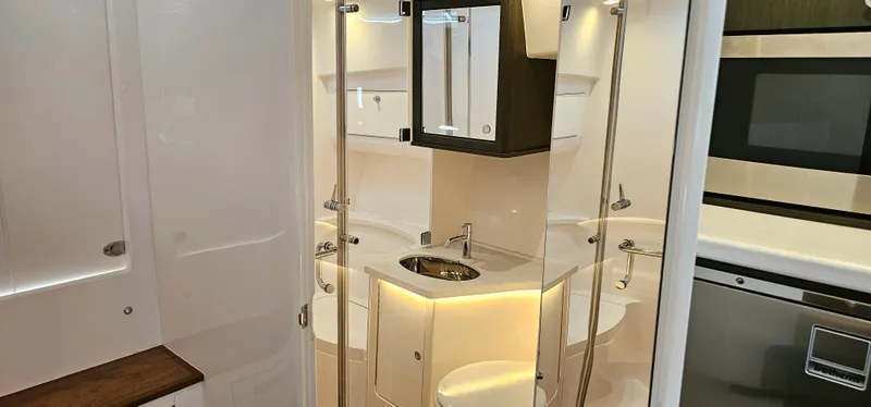 Slide: The Image of 2022 Intrepid 438 Evolution yacht bathroom with modern fixtures and ambient lighting. - 18