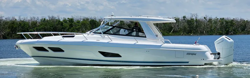 Slide: The Image of 2022 Intrepid 438 Evolution luxury boat cruising on a calm lake. - 2