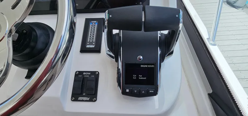 Slide: The Image of 2022 Intrepid 438 Evolution boat throttle controls and steering wheel. - 21