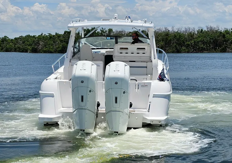 Slide: The Image of 2022 Intrepid 438 Evolution boat cruising on a lake with twin outboard engines. - 4