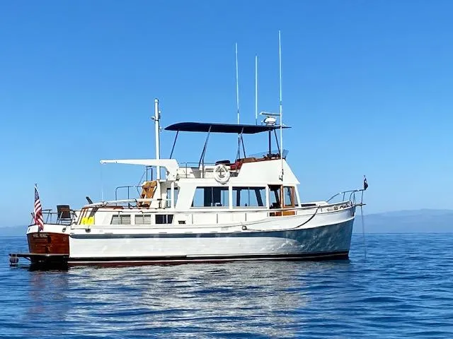 The Image of 1969 Grand Banks 42 Classic yacht on calm blue water under clear sky. - 0