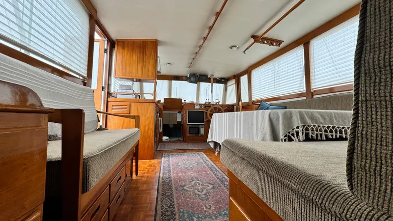 Slide: The Image of Interior of a 1969 Grand Banks 42 Classic yacht, featuring wood paneling and cozy seating. - 11