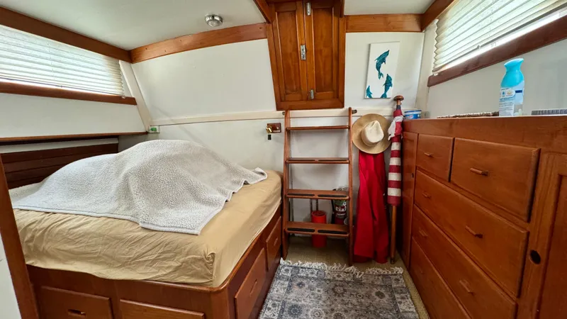 Slide: The Image of Cozy cabin interior of 1969 Grand Banks 42 Classic with bed, wooden storage, and nautical decor. - 16