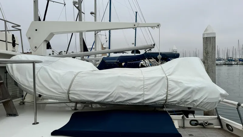 Slide: The Image of 1969 Grand Banks 42 Classic yacht with covered equipment on deck, docked at a marina. - 26