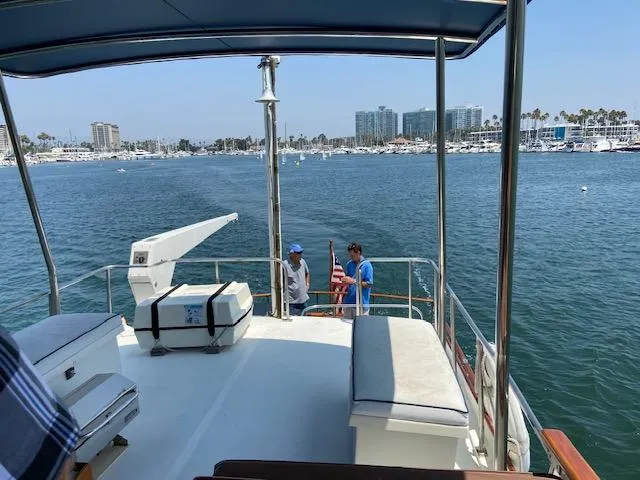 Slide: The Image of 1969 Grand Banks 42 Classic yacht cruising in a marina with two people on deck. - 32