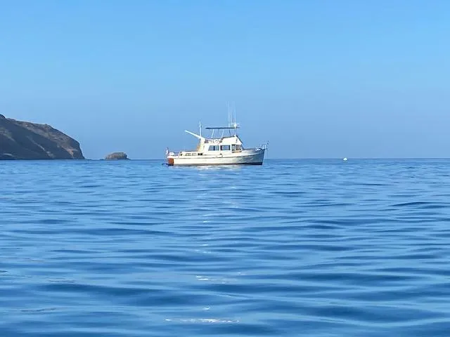 Slide: The Image of 1969 Grand Banks 42 Classic yacht on calm blue sea near rocky coastline. - 33
