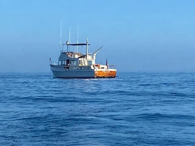Slide: The Image of Grand Banks 42 Classic yacht from 1969 on calm blue ocean waters. - 34