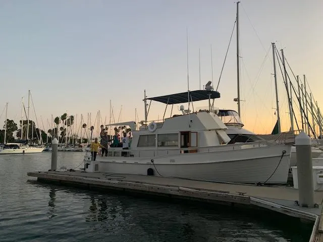 Slide: The Image of 1969 Grand Banks 42 Classic yacht docked at marina during sunset. - 37