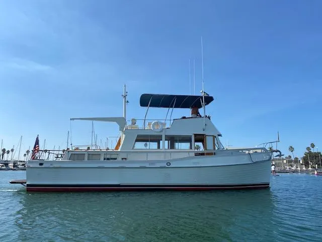 Slide: The Image of 1969 Grand Banks 42 Classic yacht on calm water under clear blue sky. - 42