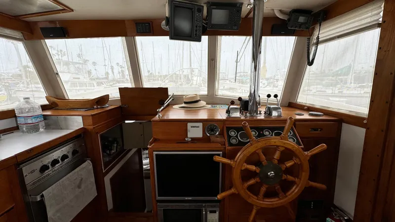 Slide: The Image of 1969 Grand Banks 42 Classic yacht interior with wooden helm and navigation equipment. - 6