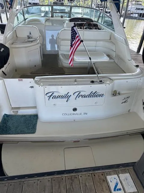 Slide: The Image of 1997 Sea Ray 330 Sundancer boat docked, named Family Tradition, with American flag. - 14