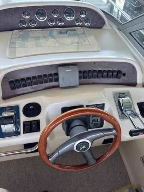 Slide: The Image of 1997 Sea Ray 330 Sundancer helm with wooden steering wheel and control panel. - 2