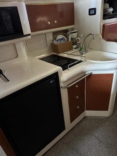 Slide: The Image of 1997 Sea Ray 330 Sundancer galley with sink, stove, microwave, and storage cabinets. - 4
