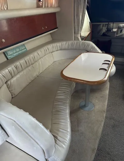 Slide: The Image of Interior of a 1997 Sea Ray 330 Sundancer with beige seating and a wooden table. - 5