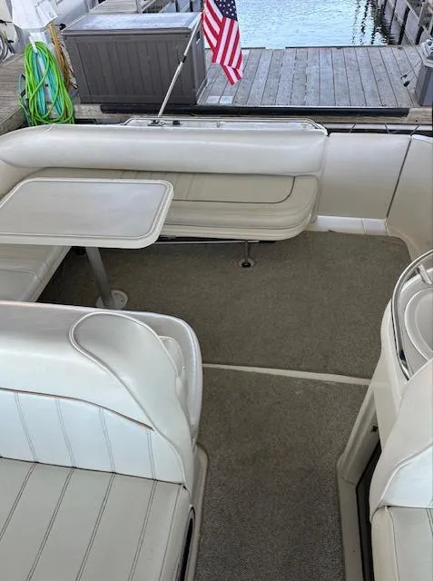 Slide: The Image of 1997 Sea Ray 330 Sundancer boat interior with seating and table, docked by the water. - 9