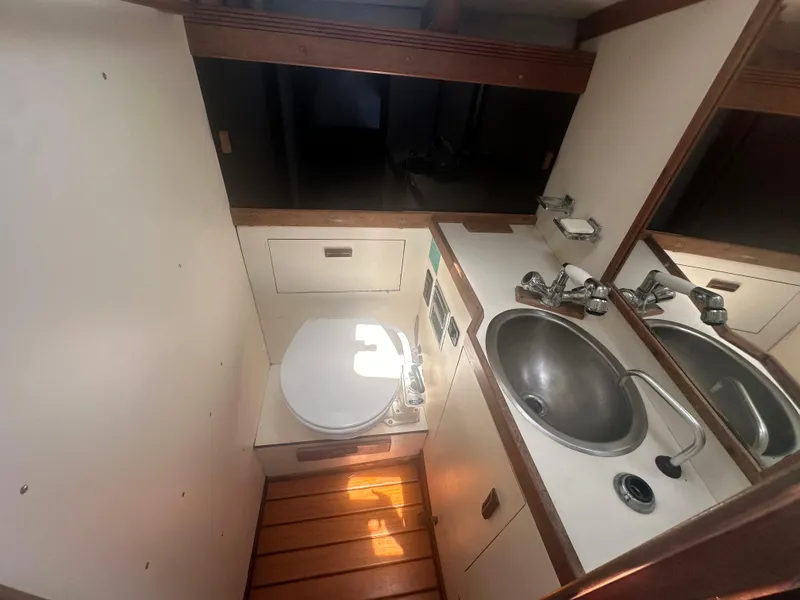 Slide: The Image of 1987 Sabre 42 yacht bathroom with sink, toilet, and wooden flooring. - 13
