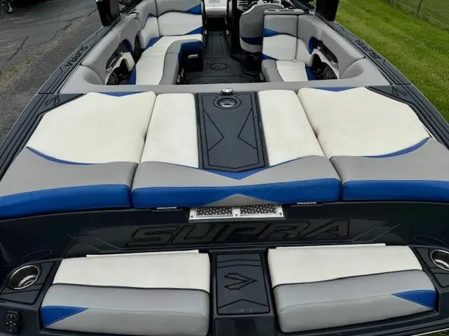 Slide: The Image of 2018 Supra SE boat interior with white, gray, and blue seating. - 9