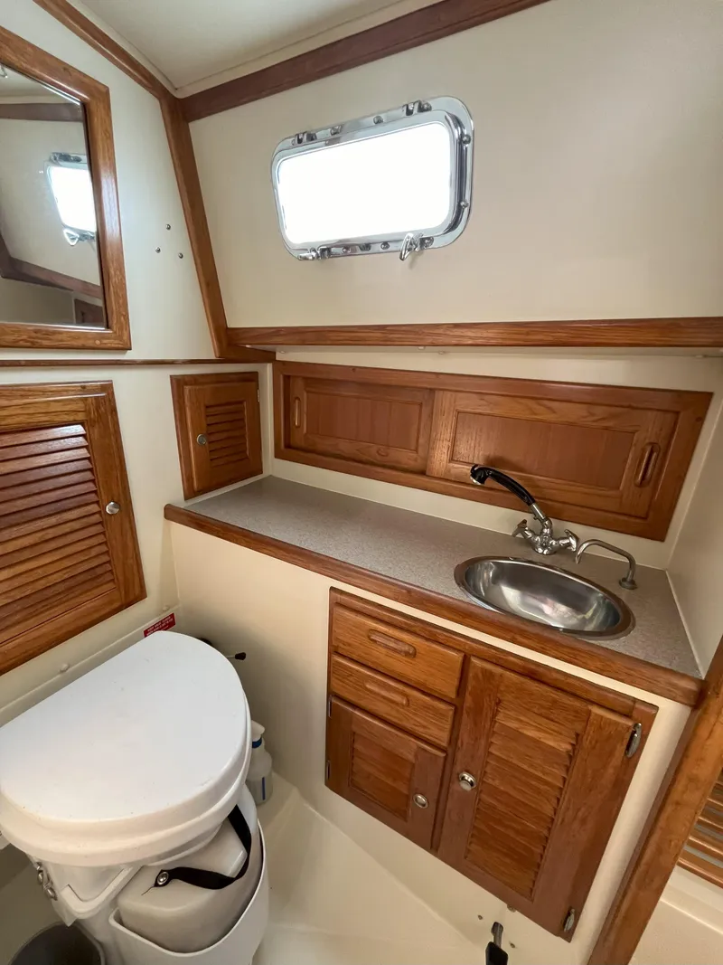 Slide: The Image of Interior of a 1998 Pacific Seacraft 40 yacht bathroom with wooden cabinets, sink, and toilet. - 16