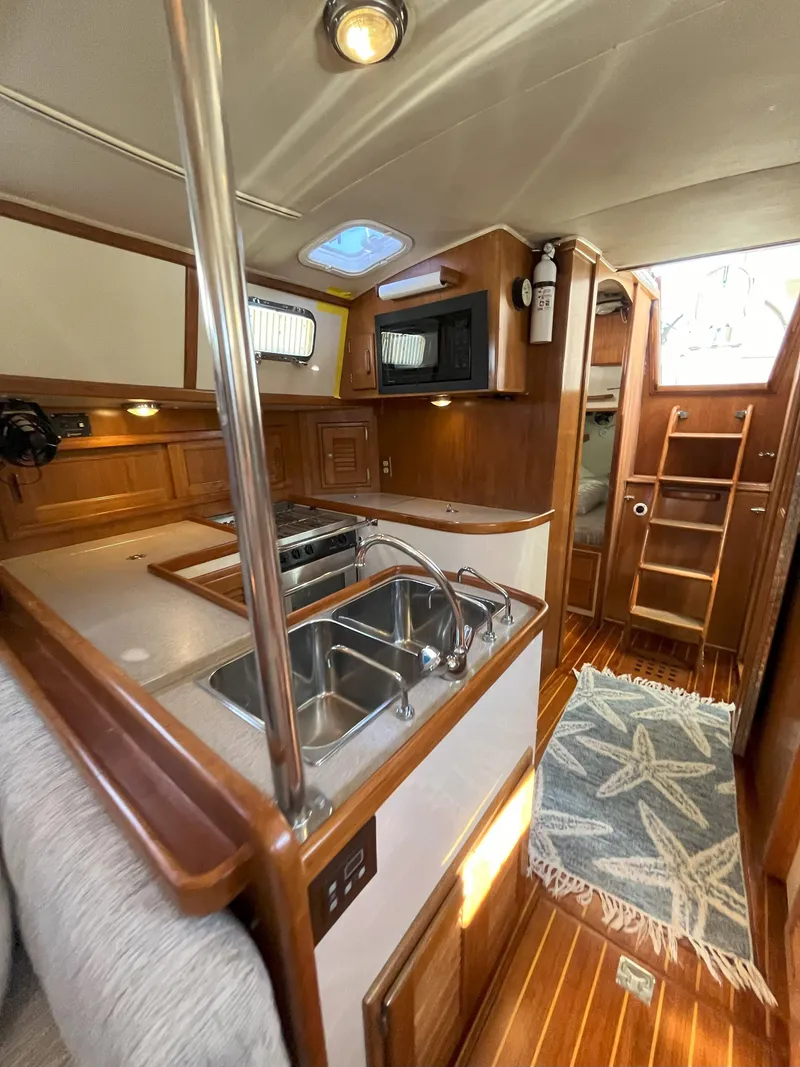 Slide: The Image of Interior of a 1998 Pacific Seacraft 40 yacht with kitchen and wood paneling. - 36