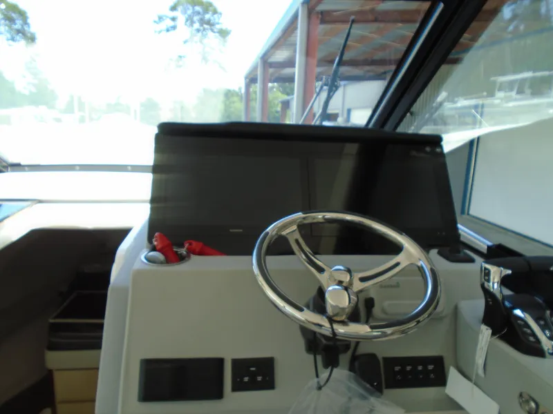 Slide: The Image of 2024 Regal 36XO boat helm with steering wheel and control panel. - 15