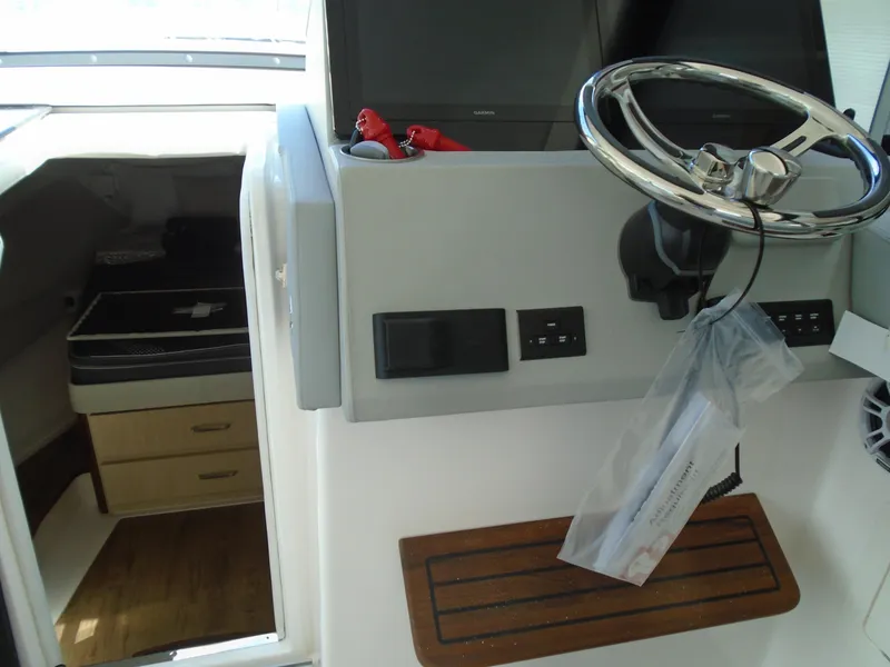 Slide: The Image of 2024 Regal 36XO boat helm with steering wheel and cabin entrance. - 18