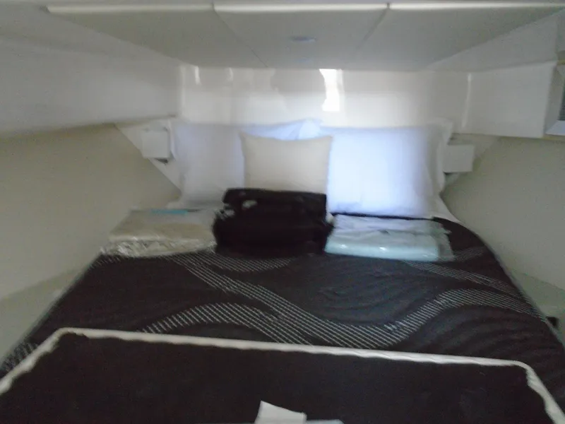 Slide: The Image of 2024 Regal 36XO cabin with a neatly made bed and pillows. - 22