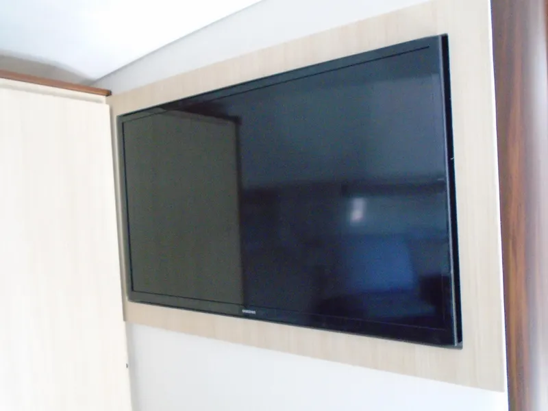 Slide: The Image of Flat-screen TV mounted on a 2024 Regal 36XO yacht interior wall. - 26