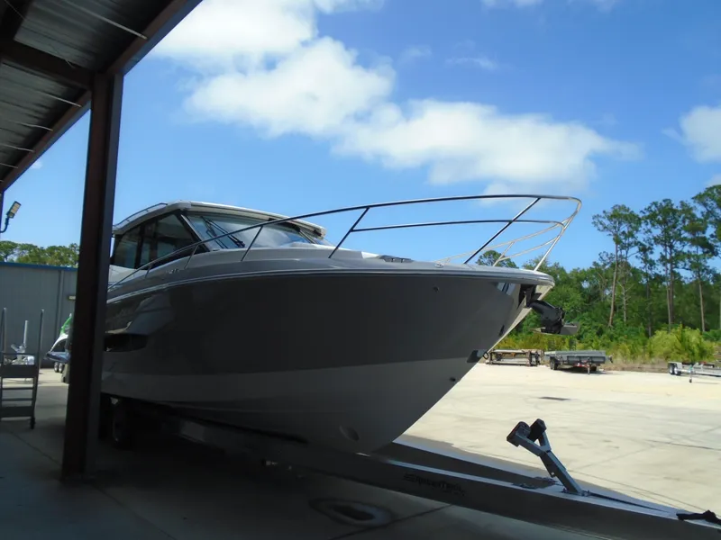 Slide: The Image of 2024 Regal 36XO boat on trailer under shelter, clear sky background. - 40