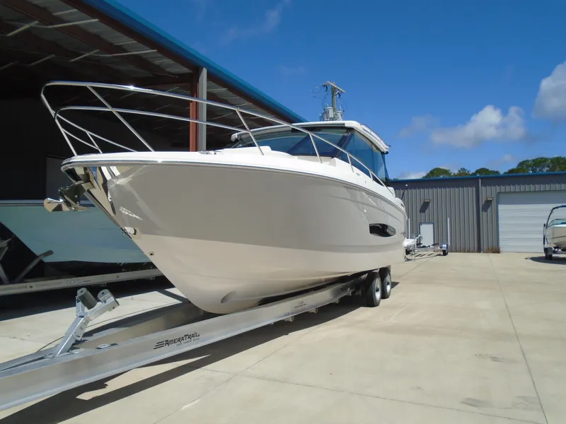 Slide: The Image of 2024 Regal 36XO boat on trailer in marina under clear blue sky. - 44