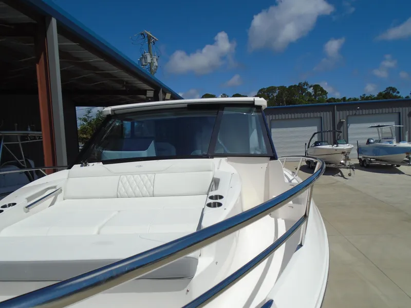 Slide: The Image of 2024 Regal 36XO luxury yacht docked at a marina under a clear blue sky. - 49