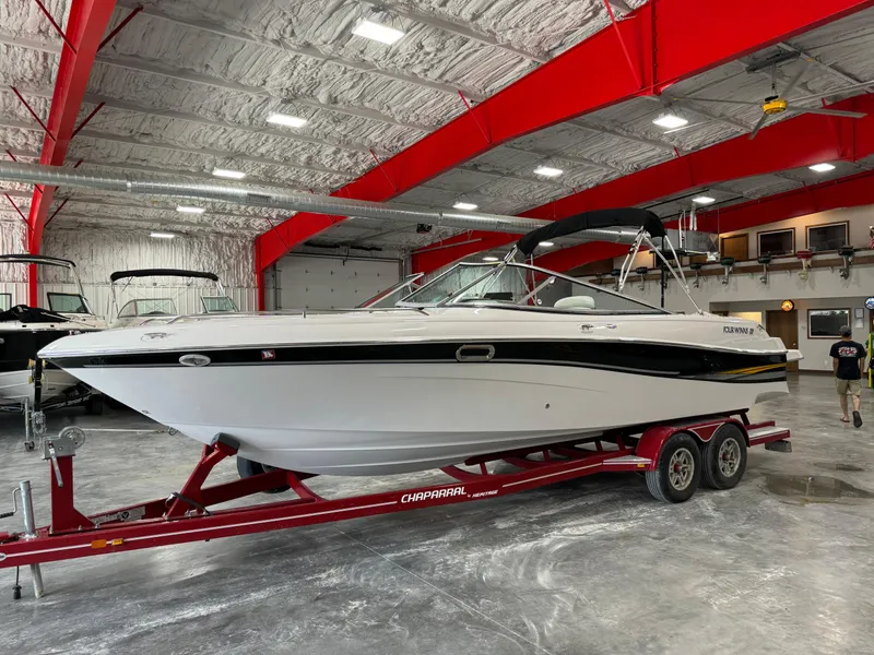 The Image of 2002 Four Winns 260 Horizon boat on a red trailer in a spacious indoor storage facility. - 0