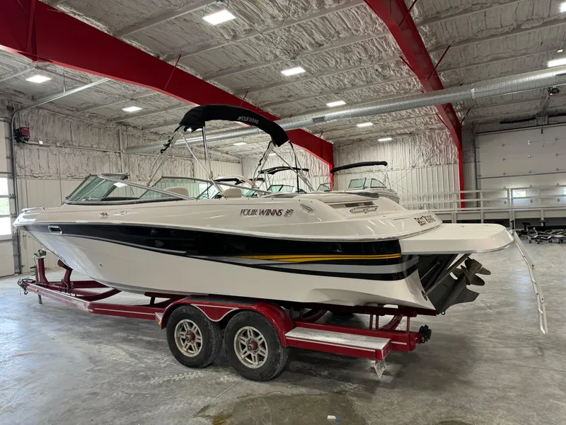 Slide: The Image of 2002 Four Winns 260 Horizon boat on a red trailer in a warehouse. - 2