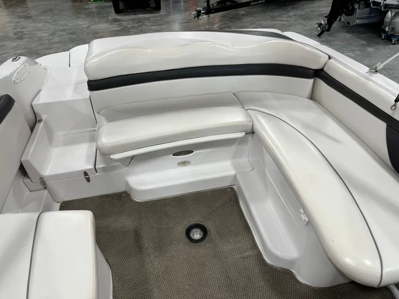 Slide: The Image of 2002 Four Winns 260 Horizon boat interior with white cushioned seating and carpeted floor. - 8