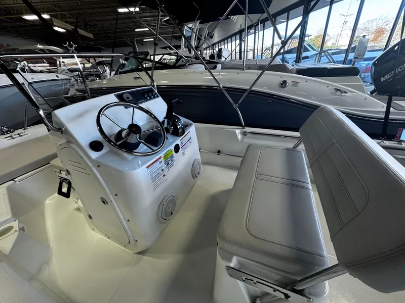 Slide: The Image of 2024 Boston Whaler 150 Montauk boat interior with steering console and seating. - 3