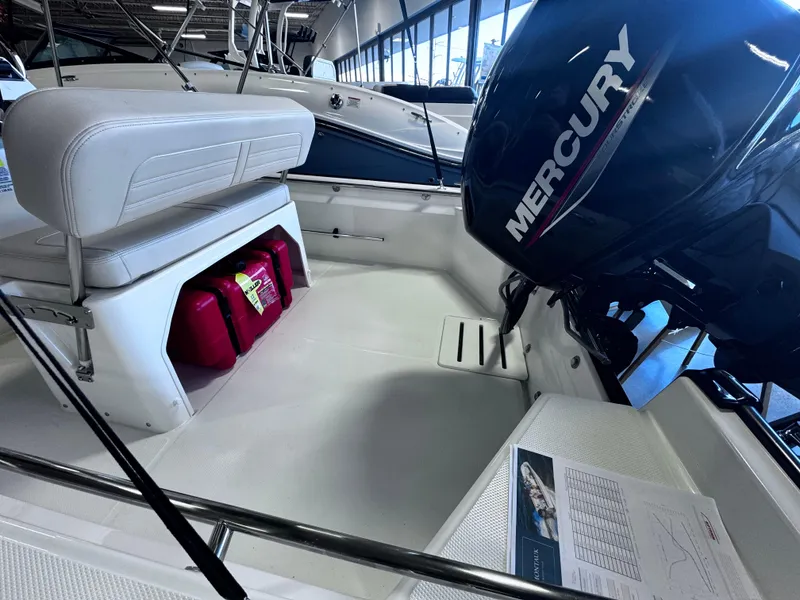 Slide: The Image of 2024 Boston Whaler 150 Montauk interior with Mercury engine and storage compartment. - 4