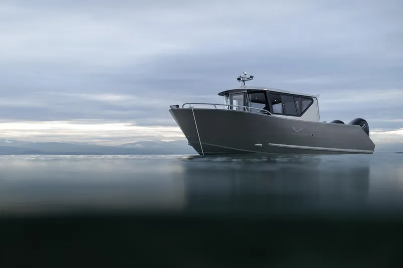 Slide: The Image of 2025 Jasper Marine Defender 22 boat on calm water under cloudy sky. - 3