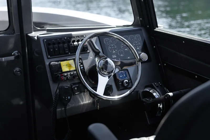 Slide: The Image of 2025 Jasper Marine Defender 22 boat cockpit with steering wheel and control panel. - 30