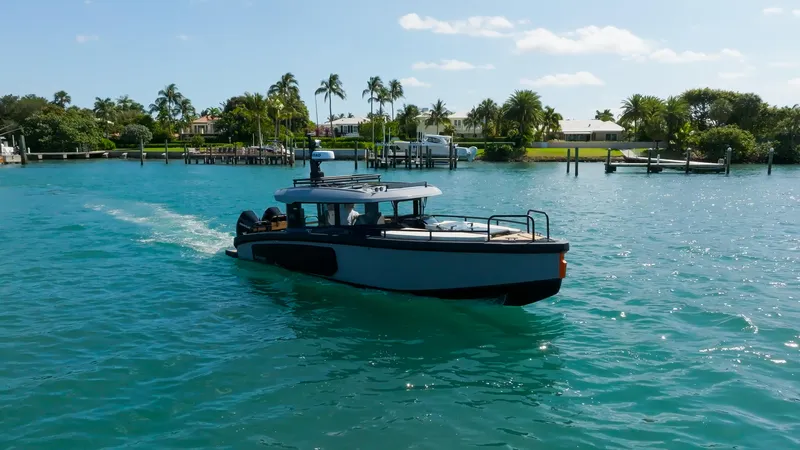 Slide: The Image of Arksen 30 boat cruising on clear blue water near a tropical shoreline, 2025 model. - 10