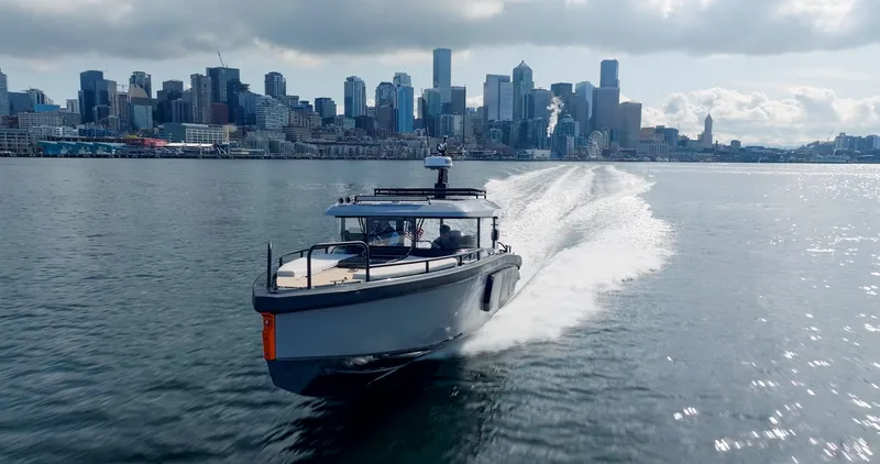 Slide: The Image of 2025 Arksen 30 boat cruising near a city skyline. - 26