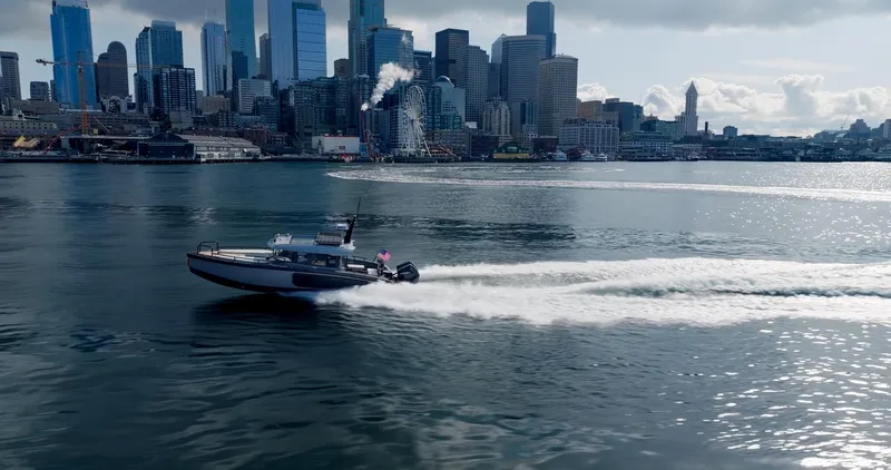 Slide: The Image of Arksen 30 boat cruising near a city skyline, 2025 model. - 28
