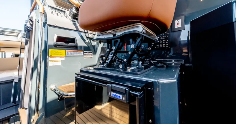 Slide: The Image of Arksen 30 boat interior, featuring a brown captain's chair and control panel, 2025 model. - 40