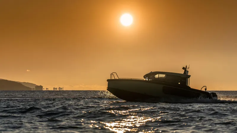 Slide: The Image of Arksen 28 boat cruising at sunset, 2025 model, on open water. - 2