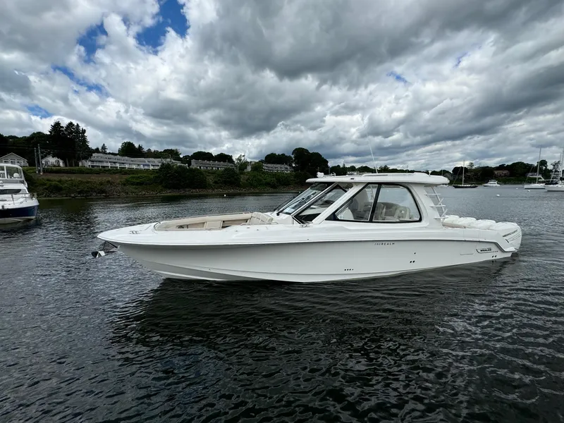 Slide: The Image of 2020 Boston Whaler 380 Realm boat on a calm waterway under cloudy skies. - 11